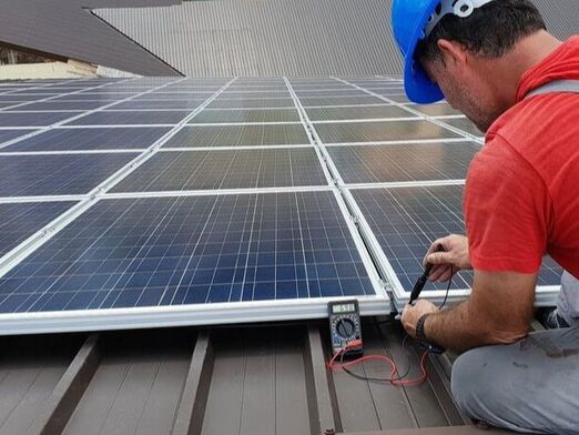Technician testing solar panels on rooftop after installation